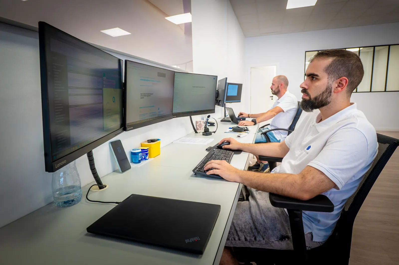 Técnico de Informàtica i Més trabajando con varias pantallas en la oficina